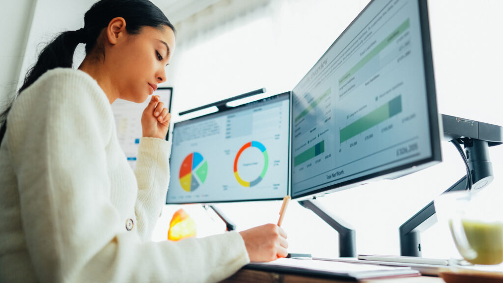 woman sitting at desk analyzing data from ga4